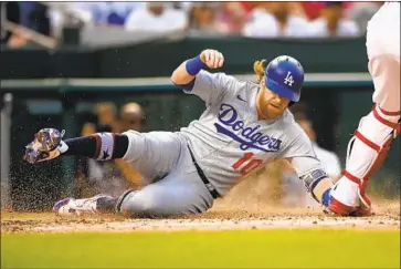  ?? Nick Wass Associated Press ?? JUSTIN TURNER slides home to score during the fourth inning of the Dodgers’ 5-3 victory over the Nationals on Saturday in Washington. It was the Dodgers’ eighth straight victory that came after a long rain delay.