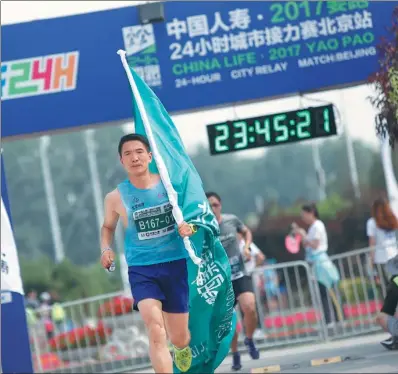  ?? PROVIDED TO CHINA DAILY ?? A runner crosses the finish line to cap his team’s Yaopao 24-Hour City Relay Match in Beijing last weekend.