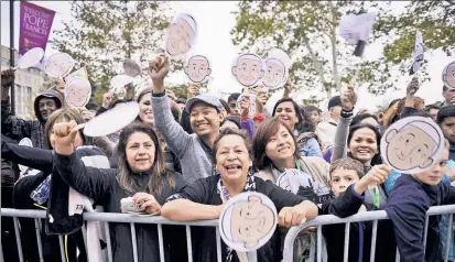  ??  ?? MASS HYSTERIA: Fans wave Pope Francis placards outside Philadelop­hia’s Basilica of Saints Peter and Paul.