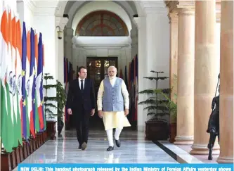  ?? —AFP ?? NEW DELHI: This handout photograph released by the Indian Ministry of Foreign Affairs yesterday shows Indian Prime Minister Narendra Modi (R) and France’s President Emmanuel Macron walking together before a meeting at Hyderabad House.