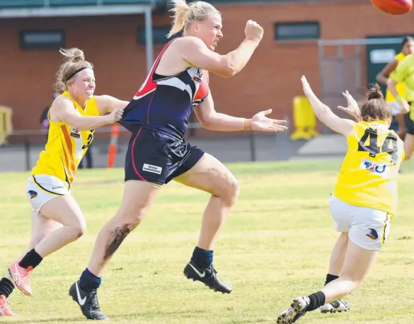  ?? Picture: NICOLE GARMSTON ?? Transgende­r footballer Hannah Mouncey gets her hand pass away for the Darebin Falcons against NT Thunder at Preston City Oval