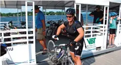  ??  ?? A bicyclist collect her bicycle after taking a special ferry across a cut in an abandoned railroad causeway from the Vermont mainland to the Lake Champlain islands.