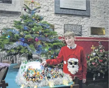  ?? ?? Oliver Peacock points out Santa on the Wright family Lego tree at the Christmas tree festival at Brompton church.