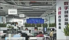  ?? ZHANG CHENLIN / XINHUA ?? Employees work at a financial tech company in Beijing.