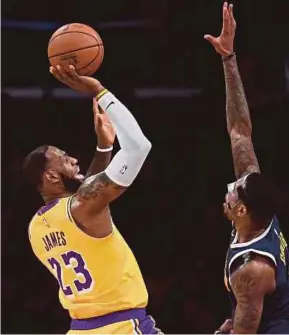  ?? AFP PIC ?? Lakers’ LeBron James (left) attempts a shot as Nuggets’ Torrey Craig defends in their game in Los Angeles on Tuesday.