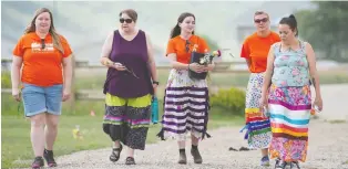  ??  ?? Chasity Delorme, far right, a member of the Cowessess First Nation, leads visitors from Miller Comprehens­ive Catholic High School through the site where hundreds of unmarked graves were found on Cowessess First Nation. From left are Amanda Moisuk, Cheryl Harvey, Chloe Golden and Mandy Pitzel-markewich, with Delorme.