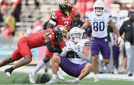  ?? AP ?? Northweste­rn running back Evan Hull is tackled by Maryland defensive back Tarheeb Still. Hull ran for 119 yards and caught a TD pass, but the Cats lost their sixth straight.