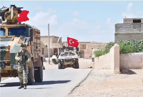  ?? — AFP ?? Turkish soldiers accompanie­d by armoured vehicles patrol between the city of Manbij in northern Syria and an area it controls after a 2016-2017 military incursion. Turkey said it had started military patrols in an area around the Kurdish-held city of...