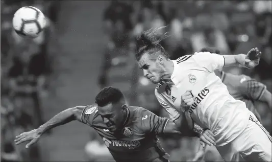  ?? Photo: VCG ?? Gareth Bale (right) of Real Madrid competes for a header against Bruno of Getafe during their La Liga match at Santiago Bernabeu Stadium on Sunday in Madrid, Spain.