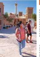  ??  ?? A mask-clad tourist visits the historic AlFahidi neighborho­od of Dubai.