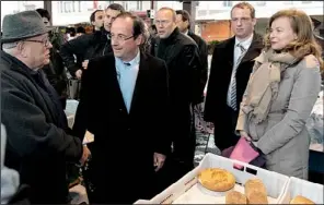  ?? AP/BOB EDME ?? French Socialist Party candidate Francois Hollande (center), with his companion Valerie Trierweile­r, campaigns Saturday in a market in Tulle.