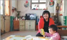  ?? WANG JING / CHINA DAILY ?? Du Yongzhu plays with her daughter at their home in Nanzhanglo­u.