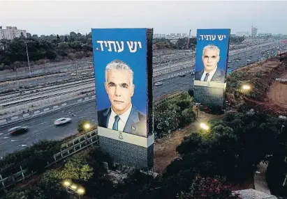  ?? Amir Levy / Getty ?? primer a "amat #an. A la dreta d$aquestes l%nies, cartells !e!ants del primer ministre &air Lapid a prop de 'elAviv
