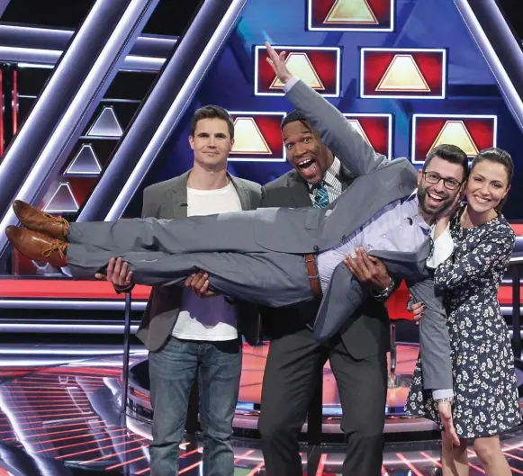  ?? LOU ROCCO/ABC ?? Actor Robbie Amell, host Michael Strahan and Amell’s wife, actress Italia Ricci, hold up contestant Jacob Pfeffer on The $100,000 Pyramid.