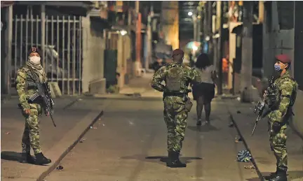  ?? ERNESTO GUZMÁN JR / EFE ?? Cali. Militares patrullan las calles del Distrito de Aguablanca en esta ciudad colombiana, como parte de sus labores durante la emergencia sanitaria.