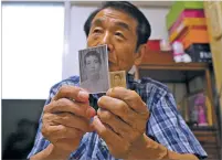  ?? AHN YOUNG-JOON/ASSOCIATED PRESS ?? Lee Soo-nam, 76, shows photos of his brother Ri Jong Song in North Korea on Friday at his home in Seoul, South Korea. Lee is among about 200 South Koreans who are crossing into North Korea for meetings with relatives they haven’t seen for decades.