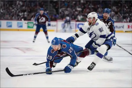  ?? The Associated Press ?? Colorado Avalanche centre Nathan MacKinnon falls in front of Tampa Bay Lightning defenceman Erik Cernak during the second period of Game 1 of the Stanley Cup final on Wednesday in Denver.