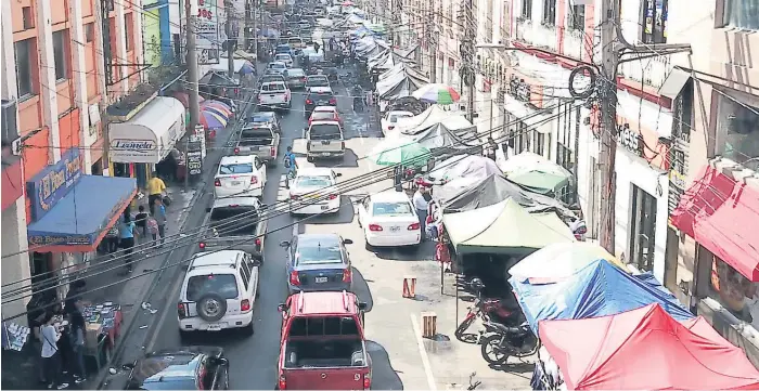  ?? FOTOS: YOSEPH AMAYA ?? PROBLEMA. Parte de la tercera avenida perdió sus aceras, que están llenas de vendedores.