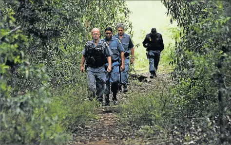  ?? Picture: SIBONGILE NGALWA ?? HIDDEN DANGER: Police search in the forest for the young woman who was kidnapped yesterday afternoon