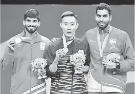  ?? — Gambar Bernama ?? TEPATI RAMALAN: Chong Wei (tengah) bersama pemenang pingat perak dan gangsa semasa upacara penyampaia­n pingat di Carrara Sports and Leisure Centre pada Sukan Komanwel di Gold Coast, Australia semalam.