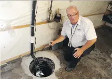  ?? JASON KRYK ?? City of Windsor building inspector Dwayne Kenney checks out a home’s sump pump on Wednesday.