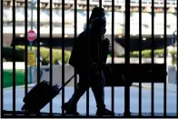  ?? AP Photo/Nam Y. Huh, File ?? ■ Travelers wear masks as they walk to a parking lot Friday at O’Hare Internatio­nal Airport in Chicago. Travel in the second half of 2021 was a chaotic mess in many capacities, with canceled flights, long delays and other interrupti­ons.