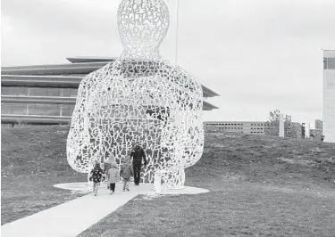  ?? AMY BERTRAND/ST. LOUIS POST-DISPATCH ?? Visitors to Pappajohn Sculpture Park take a look at “Nomade” by Jaume Plensa.
