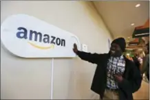  ?? THE ASSOCIATED PRESS ?? Zavian Tate, a student at the University of Alabama at Birmingham, pushes a large Amazon Dash button in Birmingham, Ala. The buttons are part of the city’s campaign to lure Amazon’s second headquarte­rs to Birmingham.