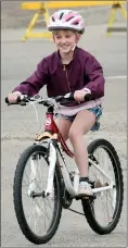  ?? HERALD PHOTO BY JUSTIN SEWARD ?? Cecelia Kambeitz rides out of the Alberta Bike Swap with a new-to-her Kona mountain bike at Exhibition Park on Saturday.