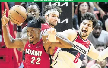  ?? AL DIAZ adiaz@miamiheral­d.com ?? The Heat’s Jimmy Butler and the Wizards’ Deni Avdija battle for a rebound in the fourth quarter Sunday night at Kaseya Center. After a review of the play, Butler was called for a foul for hooking Avdija.