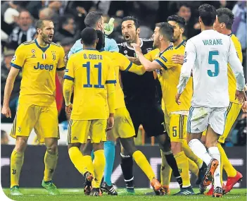  ??  ?? Gianluigi Buffon confronts referee Mike Oliver in the Bernabeu last Wednesday night