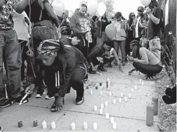  ?? JOHN J. KIM/CHICAGO TRIBUNE ?? Precious Richardson, left, lights candles during a vigil for her uncle, Maurice Granton Jr., in the 4700 block of South Prairie Avenue on June 7, 2018, in Chicago. Granton was fatally shot by Chicago police during a foot pursuit.