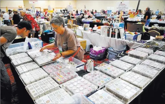  ?? Erik Verduzco ?? Las Vegas Review-journal @Erik_verduzco Wendy Schultz of Henderson shows her chip collection to Jeremy Bryant of Los Angeles on Friday at the Casino Collectibl­es Associatio­n Convention at the South Point.