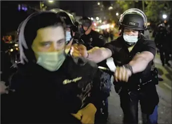  ?? Photograph­s by Wally Skalij Los Angeles Times ?? AN OFFICER pushes a protester on Glendale Avenue during last week’s sweep of the Echo Park homeless encampment. Demonstrat­ors, journalist­s and others blasted the LAPD’s response as heavy-handed.