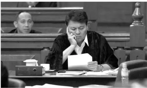  ??  ?? Senator Judge Manny Villar (center) examines a document during the impeachmen­t trial of Supreme Court Chief Justice Renato Corona at the Senate in Manila.