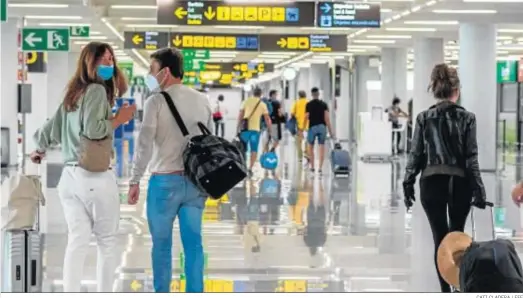  ?? CATI CLADERA / EFE ?? Viajeros a su llegada al aeropuerto de Palma de Mallorca durante el primer día del fin del primer estado de alarma, el pasado junio.