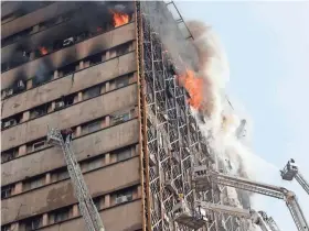  ?? EUROPEAN PRESS AGENCY ?? Firefighte­rs try to control a fire as it rises from the Plasco building in Tehran, Iran, Thursday. As the fire raged, the building collapsed, killing at least 30 firefighte­rs.