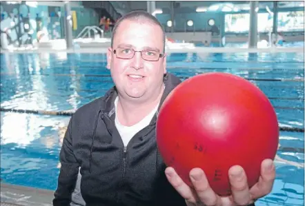 ?? Photo: KRIS DANDO ?? Big and red: Marcus Walker holds an underwater rugby ball. The rubber ball weighs about 3kg, is filled with salt water and sinks.