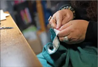  ?? Morgan Timms/The Taos News ?? Beheler replaces the elastic in a customer’s garment on Monday (Dec. 3) at her studio in the John Dunn House Shops.