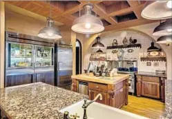  ??  ?? THE KITCHEN in the 8,213-square-foot house has commercial appliances, as well as a butler’s pantry with a warming oven.