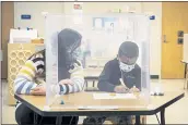  ?? ASHLEE REZIN GARCIA — CHICAGO SUN-TIMES VIA AP ?? Prekinderg­arten teacher Sarah McCarthy works with a student at Dawes Elementary in Chicago on Monday. Chicago Public Schools students began their return to the classroom Monday.