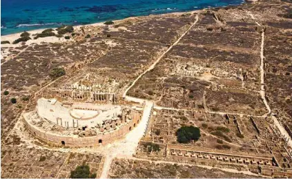  ?? ?? An aerial picture shows the remains of the semi-circular theatre and the Chalcidicu­m (right), beyond which lies the marketplac­e, and the Severan Forum and Basilica (top right), in the ancient Roman city of Leptis Magna near the coastal Libyan city of Al-Khums, 120Km east of the capital.-AFP photos