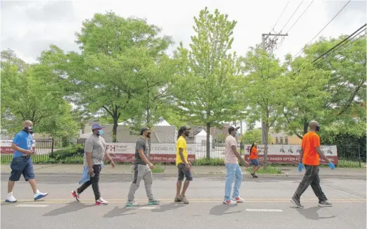  ?? ANTHONY VAZQUEZ PHOTOS/SUN-TIMES ?? Demonstrat­ors walk down South Racine Avenue during a demonstrat­ion Thursday at 79th Street in Auburn Gresham.