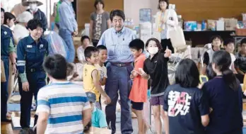  ??  ?? Prime Minister Shinzo Abe (C) visits a shelter for people affected by the recent flooding in Mabi, Okayama prefecture, on Wednesday. — AFP