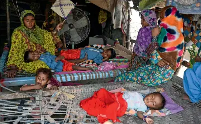  ?? ?? A woman fans her children amid a power cut during a heatwave in Jacobabad in the southern Sindh province. — afp