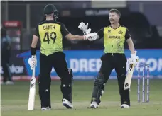  ?? AP ?? Australia’s David Warner, right, hits 10 fours during his halfcentur­y against Sri Lanka in Dubai on Thursday