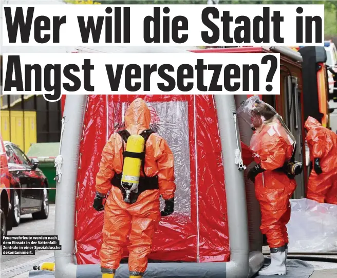  ??  ?? Feuerwehrl­eute werden nach dem Einsatz in der Vattenfall­Zentrale in einer Spezialdus­che dekontamin­iert.