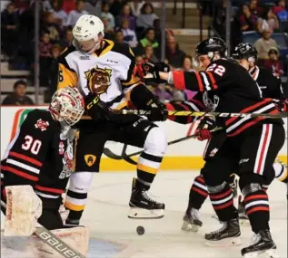  ?? BARRY GRAY, THE HAMILTON SPECTATOR ?? What a scream: Hamilton Bulldogs’ Trent Fox is hit while fighting for the puck Wednesday during the Bulldogs’ annual school day game against the Niagara IceDogs. About 11,000 kids screamed for every hit, shot and goal.