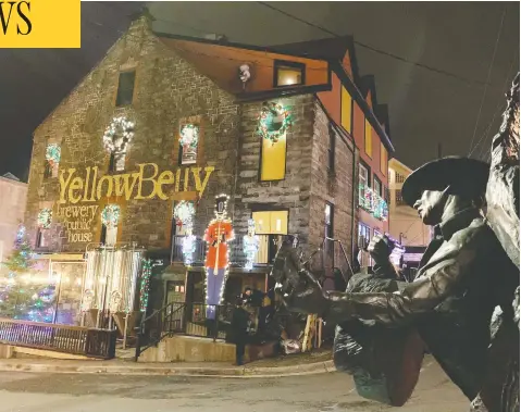  ?? SARAH SMELLIE / THE CANADIAN PRESS ?? A statue of singer Ron Hynes keeps watch over George Street in St. John's, on Tuesday, the night before Tibb's Eve in Newfoundla­nd and Labrador.