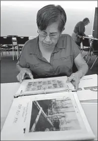  ?? NWA Media/BEN GOFF ?? Dana Roof looks through binders full of salvaged family photos at the Joplin Public Library on Saturday. Roof, who survived the May 2011 tornado in Joplin, Mo., by taking shelter in her bathtub, lost all her family photos. A volunteer group is working...